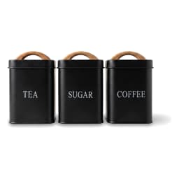 Matte black metal kitchen storage set with three small canisters labeled Sugar, Coffee, Tea, and a large bread box, all with… - view 2