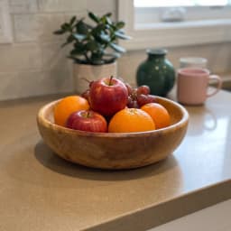 Light brown wooden serving bowl with natural wood grain visible on a white background. - view 1