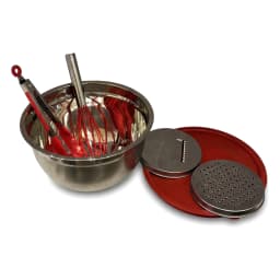 Stainless steel mixing bowl with red whisk and red lid on a light kitchen counter, next to a pink potted plant. - view 6