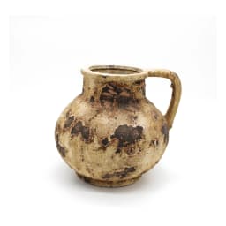 Rustic beige and brown porcelain decorative jug with a handle, holding pink roses and eucalyptus leaves on a wooden table. - view 2
