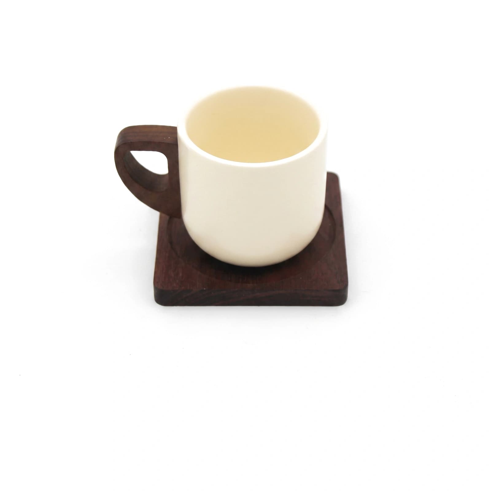 Cream ceramic mug with a dark brown wooden handle, sitting on a square dark brown wooden coaster with a circular indentation.
