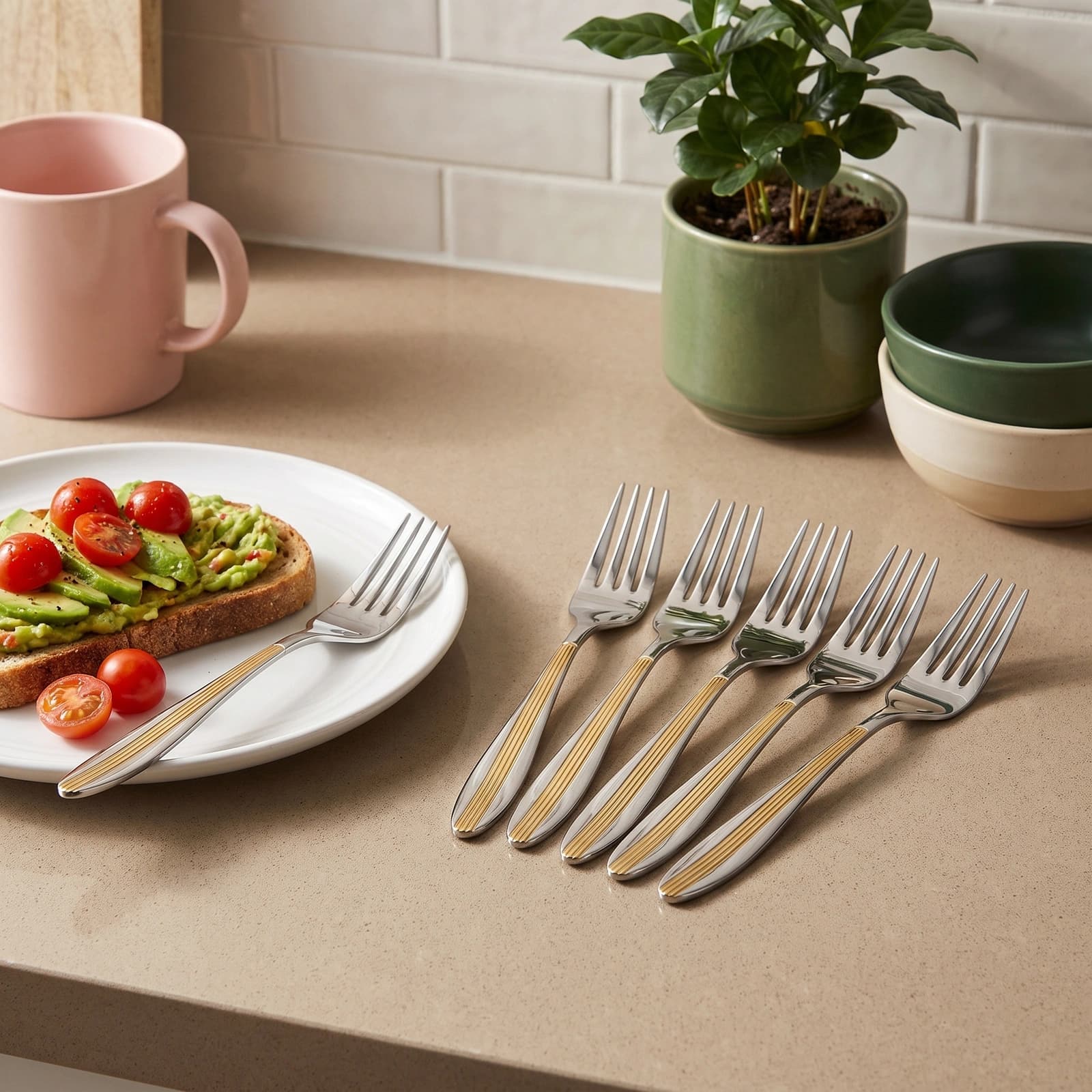 Six silver stainless steel dinner forks with gold ribbed handles, arranged in a row on a white background.