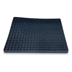 Square navy blue silicone grid coaster under a steaming terracotta tagine on a white kitchen counter - view 2