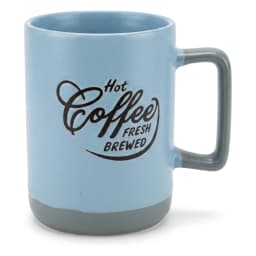 كوب سيراميك أزرق فاتح بقاعدة ويد رماديين، عليه كتابة "Hot Coffee Fresh Brewed" وبخار طالع منه، على رخامة مطبخ. - view 2