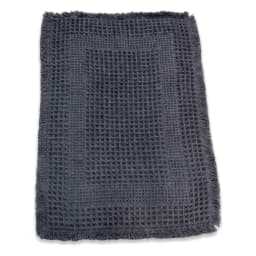 Rectangular grey waffle weave cotton bath mat with fringed edges, viewed from above on a white background. - view 2
