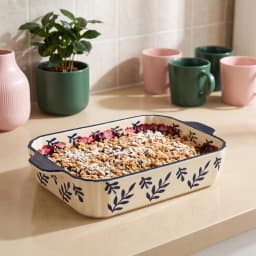 Cream porcelain rectangular baking dish with dark blue leaf pattern and handles, 13 inches, on a white surface. - view 1