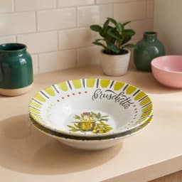 Two round white porcelain plates with a yellow-green border, olive oil bottle, olive branches, and 'bruschetta' design. - view 3