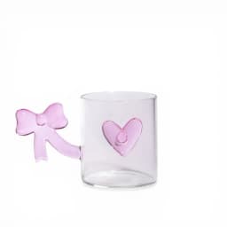 Single clear glass mug with a pink bow-shaped handle and a pink heart decoration on the side, on a white background. - view 2