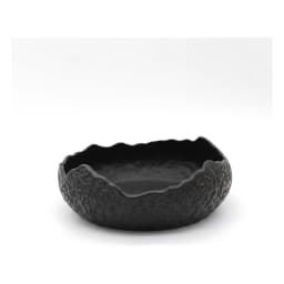 Single black porcelain serving bowl with a textured exterior and an irregular, wavy rim on a white background. - view 3