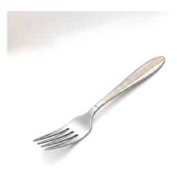 Single silver stainless steel dinner fork with gold accents on handle, next to a fruit plate on a beige counter. - view 2