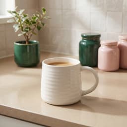 Single cream ceramic mug with horizontal ribbed texture and a handle, placed on a white shelf against a wooden background. - view 1