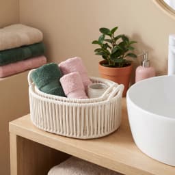 Three cream-colored oval khous nested storage baskets with integrated handles, stacked on a white background. - view 4