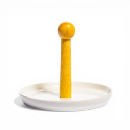Cream yellow wooden pillar paper towel holder with a white porcelain base on a kitchen counter. - view 2