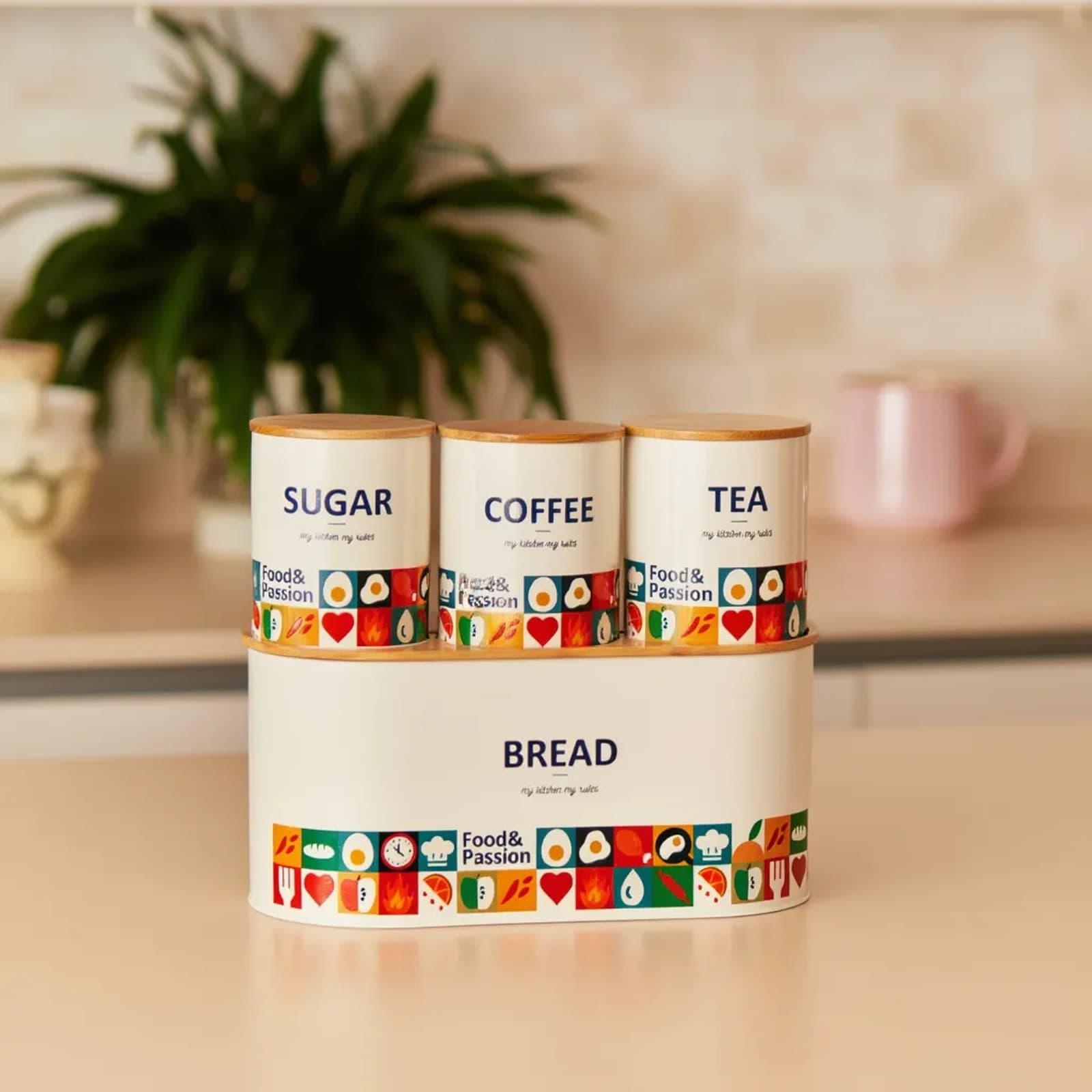 Four-piece cream metal kitchen storage set with wooden lids, featuring a large bread box and three smaller canisters for sug…