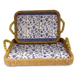 Two rectangular woven khous serving trays with blue floral plastic liners and wooden bead handles on a wooden coffee table. - view 2