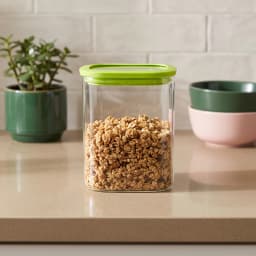 Single clear rectangular glass food storage container with a bright green airtight plastic lid on a white background. - view 1