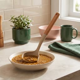 Beige silicone ladle with a light brown wooden handle, featuring a pouring spout, on a white background. - view 1