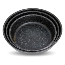 Set of three round black speckled granite baking dishes, stacked from largest to smallest, on a white surface. - view 2