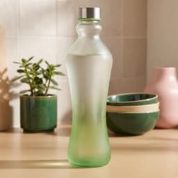 Tall frosted glass bottle with a green gradient bottom and a silver screw cap on a white background - view 1
