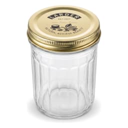 Four clear glass cylindrical storage jars with gold metal lids on a kitchen counter, filled with jam, pasta, and spices. - view 5