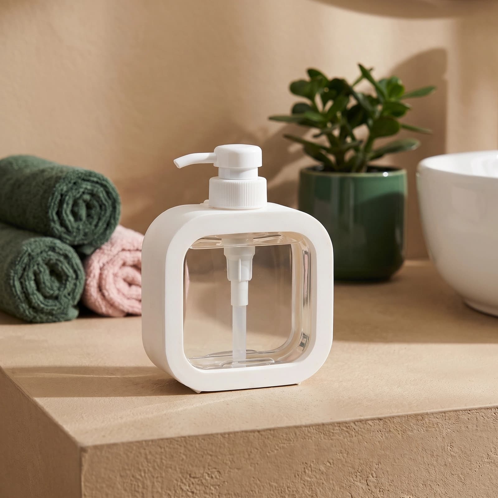 White plastic square-shaped dispenser bottle with a clear inner container and a white pump on a white background