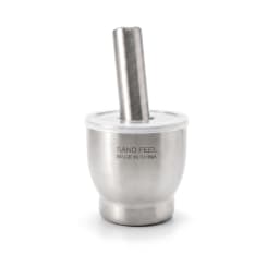Silver brushed stainless steel mortar and pestle set with a clear plastic lid, filled with spices, on a light kitchen counte… - view 2