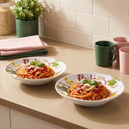 Two white porcelain deep plates with colorful pasta, tomato, mushroom, and parsley illustrations, stacked on a white backgro… - view 1