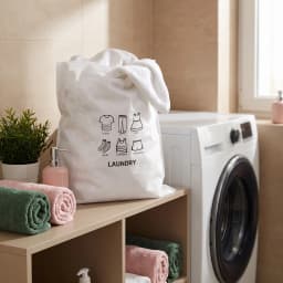 White non-woven fabric laundry bag with black line art icons of a t-shirt, pants, skirt, socks, underwear, and 'LAUNDRY' tex… - view 1