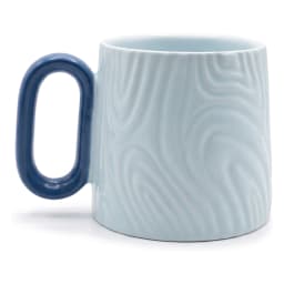 Light blue ceramic mug with a subtle swirl pattern and a dark blue handle, on a white surface with a wooden background. - view 2