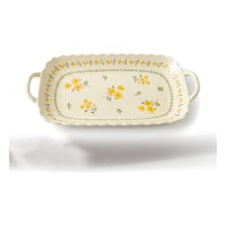Cream porcelain serving tray with yellow floral design and wavy edges, holding appetizers, grapes, and cheese on a kitchen c… - view 2