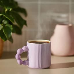 Single light purple ceramic mug with vertical ridges and a unique bubble-shaped handle, on a white background. - view 1