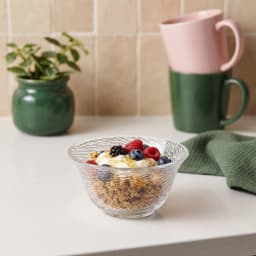 Stack of four clear textured glass serving bowls with a ribbed pattern on a white background - view 1