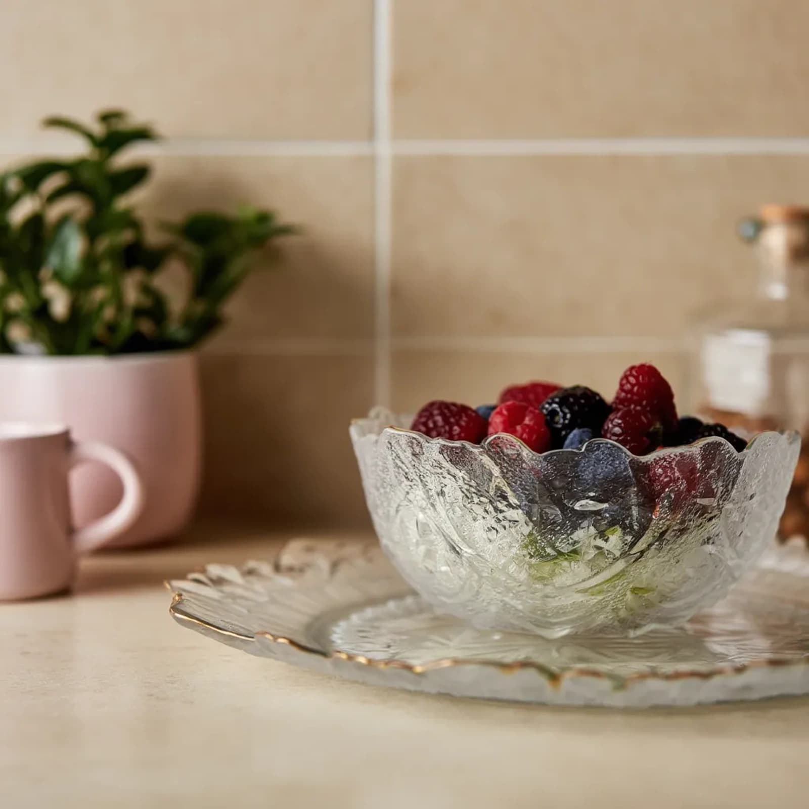 Clear textured glass serving bowl and rectangular plate with irregular wavy gold rims on a white background
