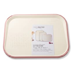 Cream plastic cutting board with pink trim, holding chopped bell peppers, cucumber, onion, and parsley on a kitchen counter. - view 2