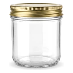 Four clear glass cylindrical storage jars with gold metal lids on a kitchen counter, filled with jam, pasta, and spices. - view 6