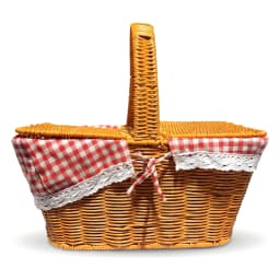 Brown woven picnic basket with red and white gingham lining, filled with grapes, cheese, bread, and a bottle, on a kitchen c… - view 4