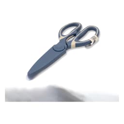 One pair of dark blue and cream silicone handle kitchen shears with serrated edge on a white shelf. - view 2