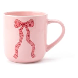 Single light pink ceramic mug with a red polka dot ribbon design on a white background, showing the handle. - view 2