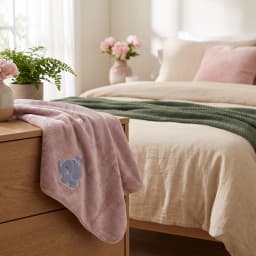 Single pink microfiber towel with a small blue and grey elephant design, hanging against a white background. - view 4