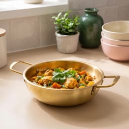Steaming gold-tone stainless steel cooking pot with two handles, filled with chicken and vegetable curry on a kitchen counte… - view 3
