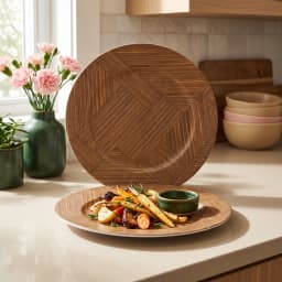 Two round brown melamine plates with a geometric wood grain pattern and white undersides, one standing, one lying flat. - view 1