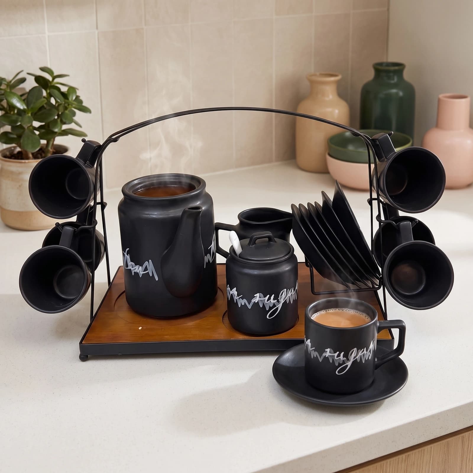 Complete 17-piece black ceramic coffee and tea set on a dark wooden tray with a black metal stand, white background.